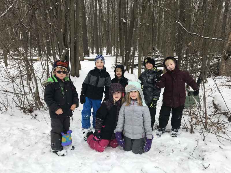 kids posing outside in the snow with their snow gear on